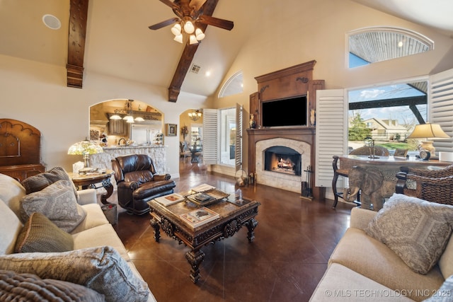 living room featuring visible vents, ceiling fan, a lit fireplace, beam ceiling, and high vaulted ceiling
