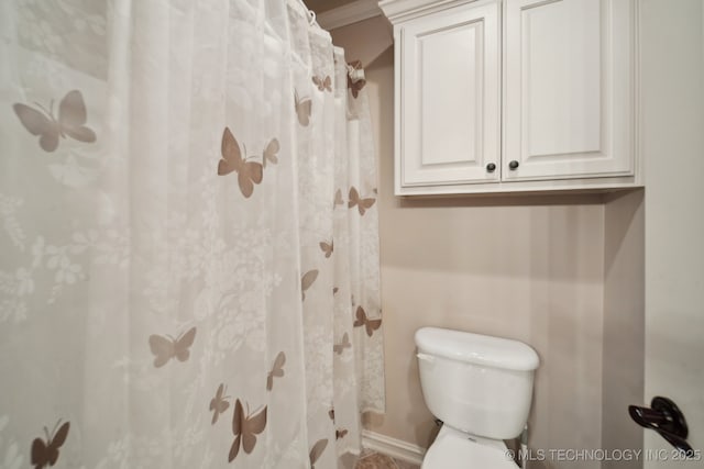 bathroom with toilet and a shower with curtain