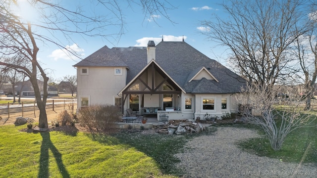 rear view of property with a yard, a chimney, fence, and roof with shingles