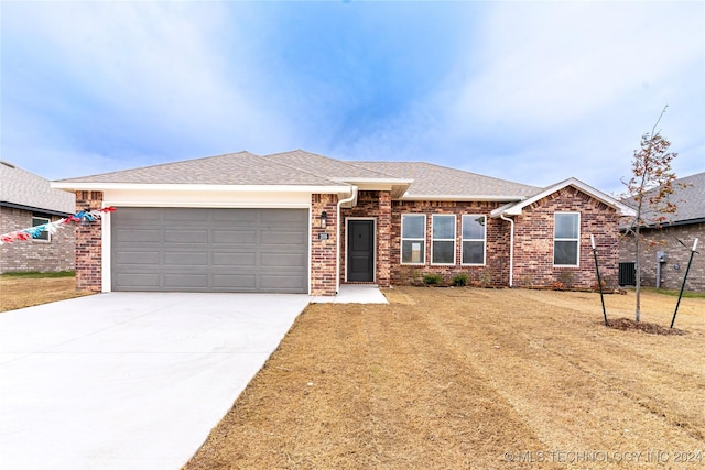 ranch-style house with a front yard, central AC, and a garage