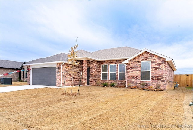 ranch-style house with cooling unit and a garage