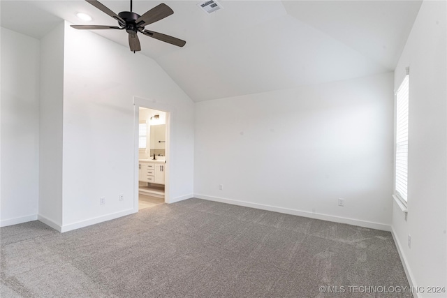 carpeted empty room with ceiling fan, plenty of natural light, and vaulted ceiling