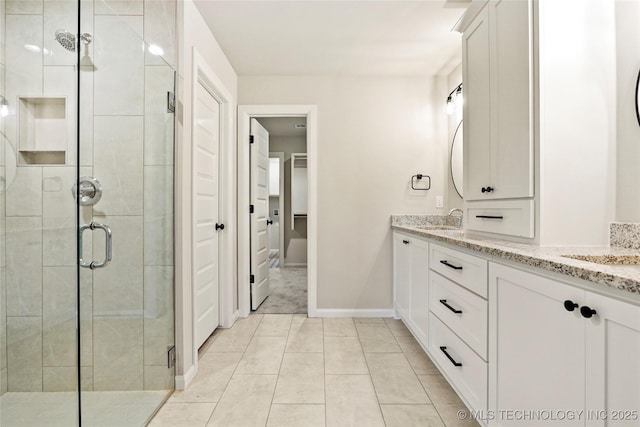 bathroom featuring tile patterned flooring, vanity, and a shower with shower door