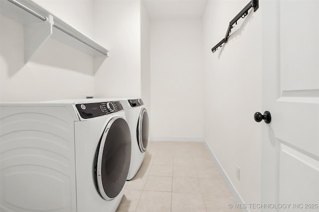 laundry room featuring washer and clothes dryer and light tile patterned flooring