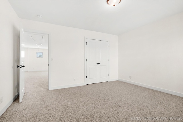 unfurnished bedroom featuring light carpet and a closet