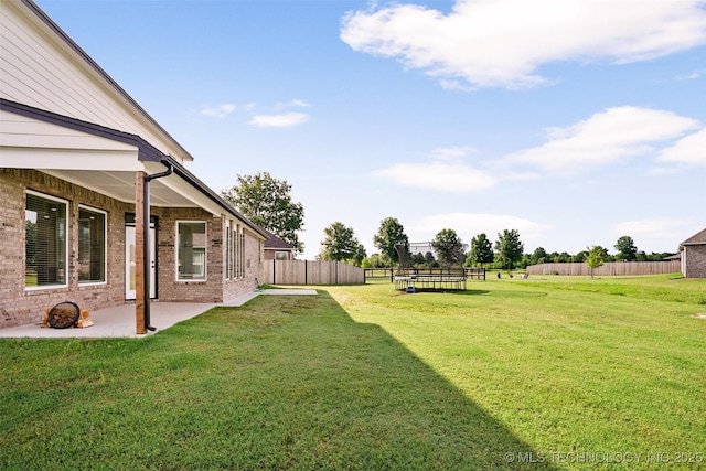 view of yard featuring a trampoline and a patio area