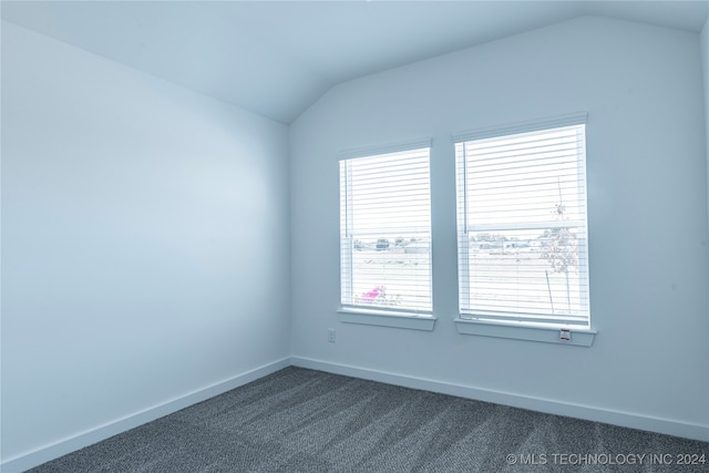 carpeted empty room featuring lofted ceiling