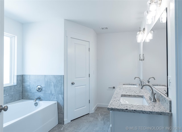 bathroom featuring tile patterned flooring, vanity, and a bathtub