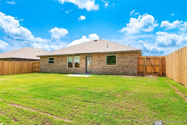 rear view of property with a lawn