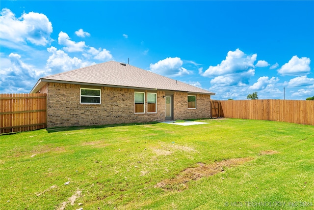 back of house with a lawn