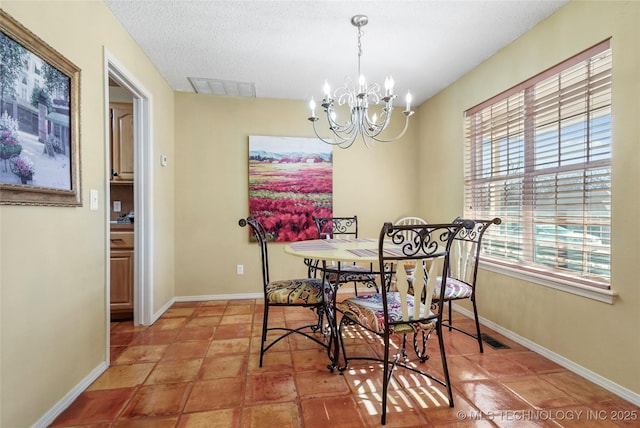 dining area with tile patterned flooring, a textured ceiling, and a chandelier