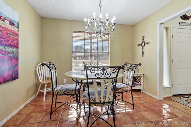 tiled dining room featuring a textured ceiling and an inviting chandelier