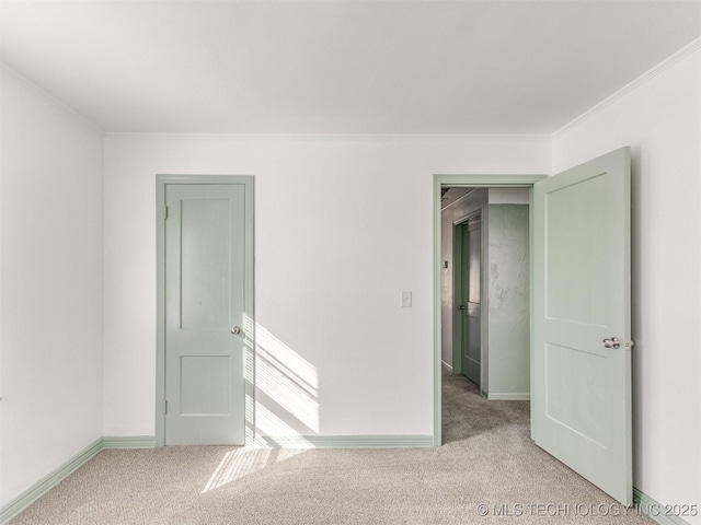 empty room featuring light carpet and crown molding