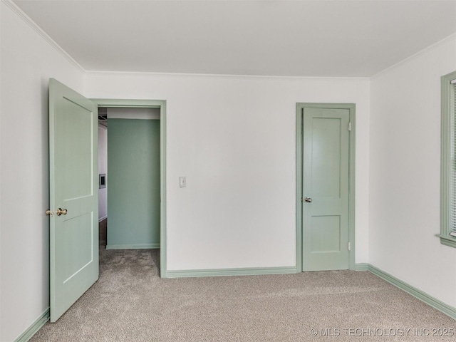 empty room with ornamental molding and light carpet