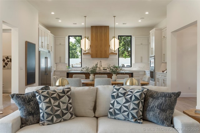 kitchen with decorative light fixtures, a center island, stainless steel appliances, and plenty of natural light