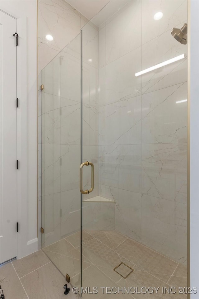 bathroom with tile patterned floors and a shower with door