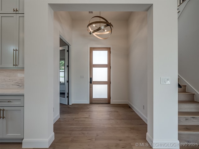 foyer featuring light hardwood / wood-style floors and a notable chandelier