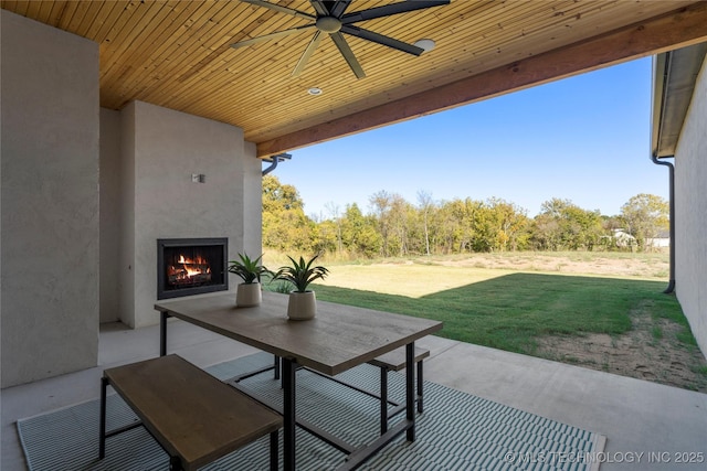 view of patio featuring ceiling fan and an outdoor fireplace