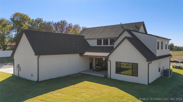 rear view of house featuring a patio area, a yard, and central AC