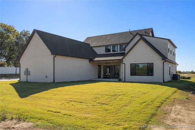 rear view of property featuring a lawn, central AC, and a patio area