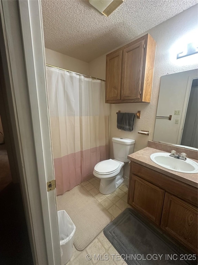 bathroom with vanity, a textured ceiling, and toilet