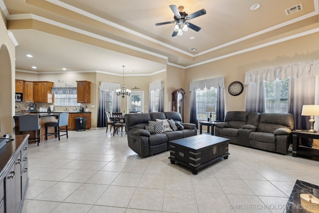 tiled living room featuring ceiling fan with notable chandelier and crown molding