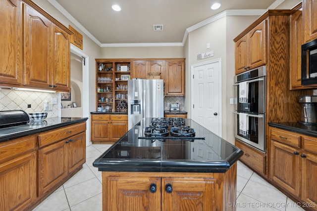 kitchen with light tile patterned flooring, decorative backsplash, a kitchen island, and stainless steel appliances