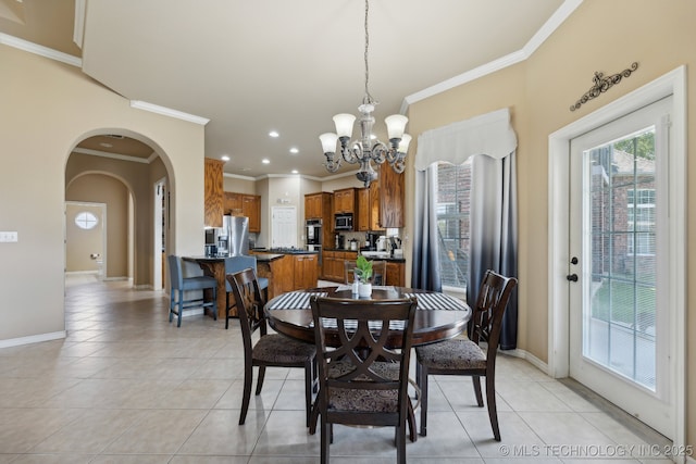 dining room with a chandelier, ornamental molding, and light tile patterned flooring