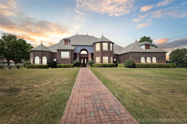 french country inspired facade with a yard and french doors