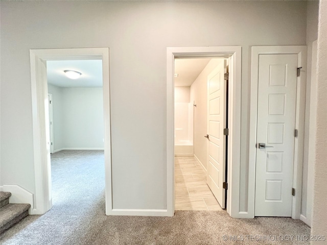 hall featuring light colored carpet