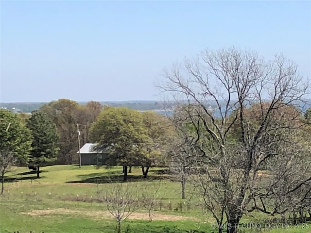 view of community featuring a lawn and a rural view