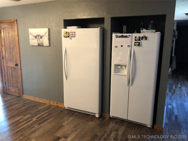 kitchen featuring white refrigerator with ice dispenser, white refrigerator, and dark wood-type flooring