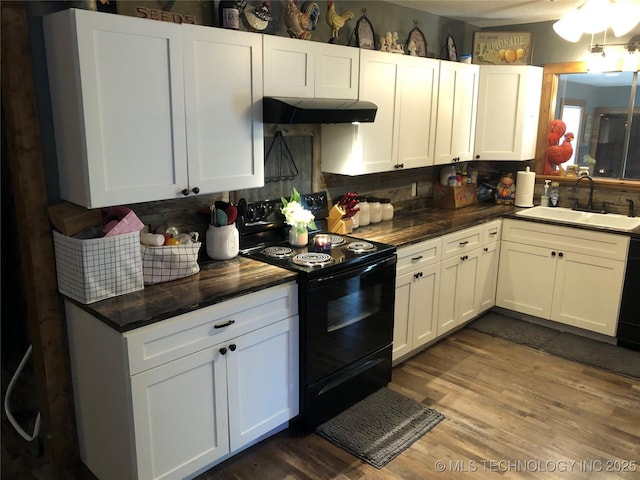 kitchen with sink, dark hardwood / wood-style flooring, backsplash, white cabinets, and black appliances