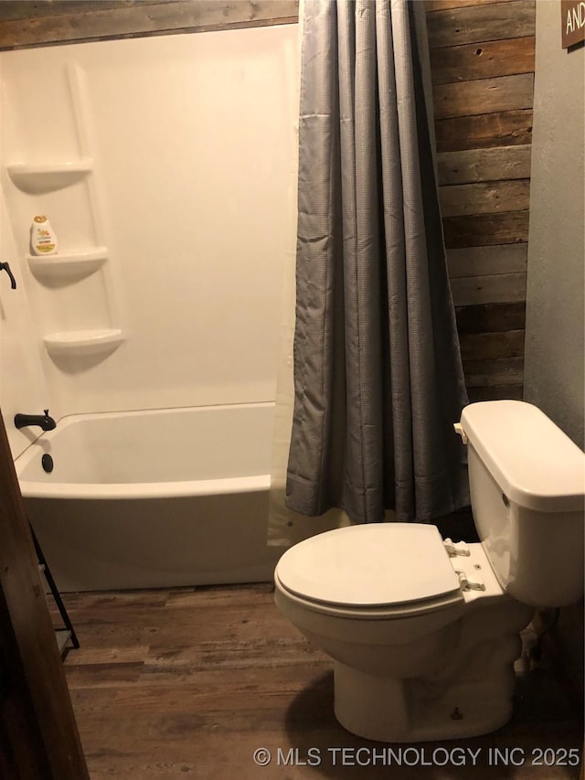 bathroom with shower / tub combo with curtain, wood-type flooring, and toilet