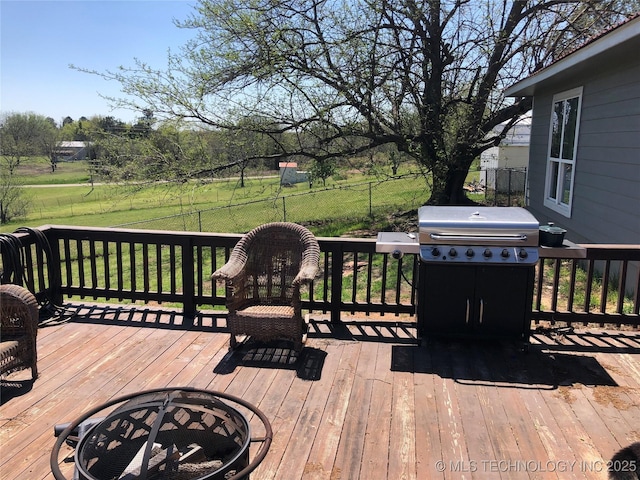 deck with a lawn, area for grilling, and an outdoor fire pit