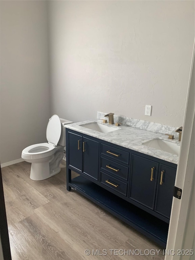 bathroom with toilet, vanity, and hardwood / wood-style flooring