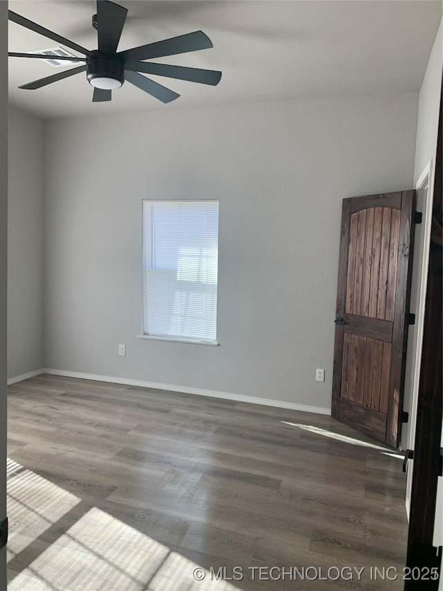 spare room with ceiling fan and dark hardwood / wood-style flooring