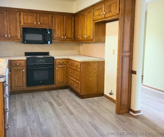 kitchen with black appliances and light wood-type flooring