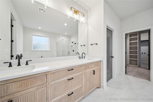full bathroom with a sink, a stall shower, a walk in closet, marble finish floor, and visible vents