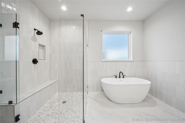 bathroom featuring a soaking tub, tile walls, recessed lighting, and a stall shower