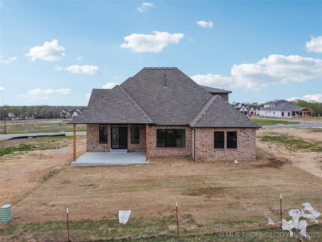 2509 E 134th Cir, Bixby, OK 74008 - rear view of property featuring roof with shingles, a patio, and brick siding