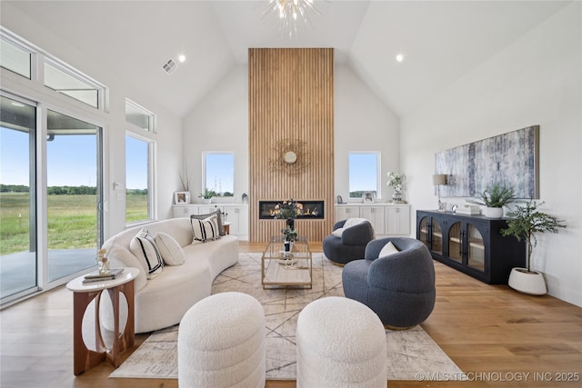 2509 E 134th Cir, Bixby, OK 74008 - living area featuring high vaulted ceiling, wood finished floors, a fireplace, and recessed lighting