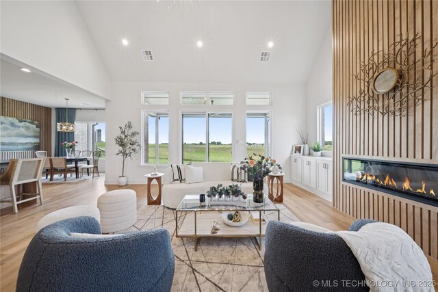 2509 E 134th Cir, Bixby, OK 74008 - living room with high vaulted ceiling, a glass covered fireplace, recessed lighting, and wood finished floors