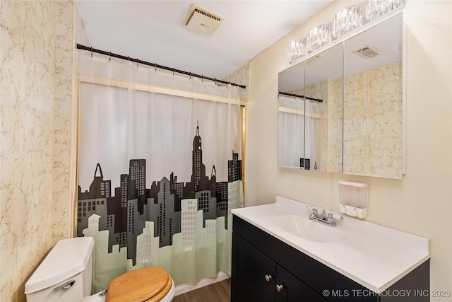 bathroom with hardwood / wood-style flooring, vanity, a shower with shower curtain, and toilet