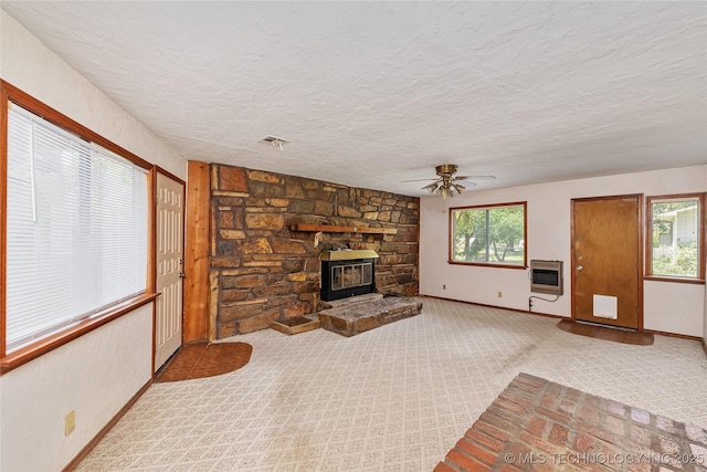 unfurnished living room with light carpet, a textured ceiling, heating unit, and ceiling fan