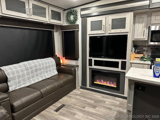 living room with light hardwood / wood-style floors and ornamental molding