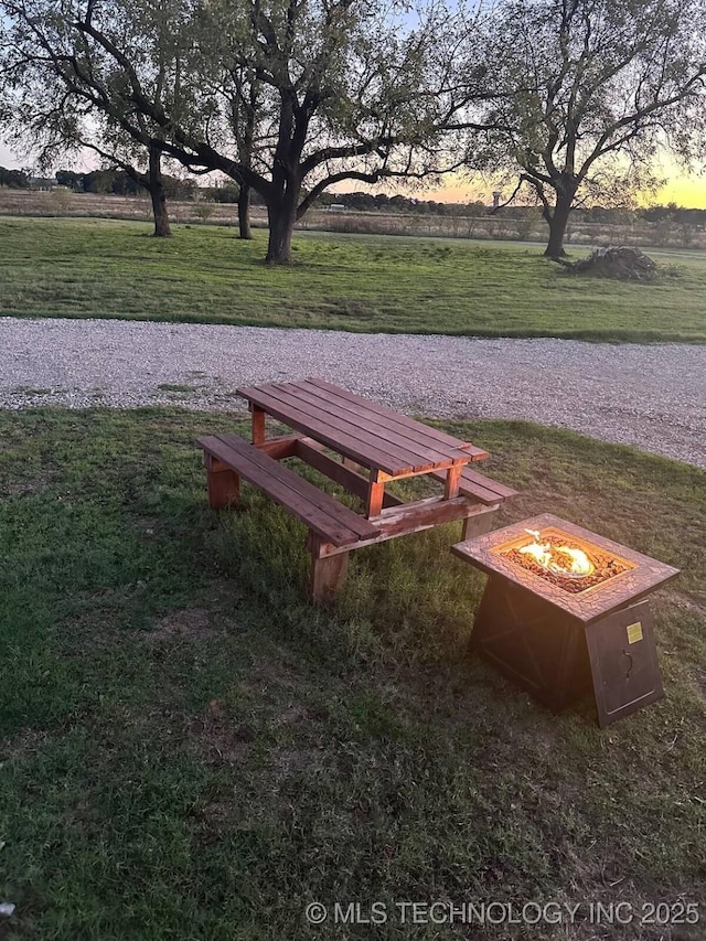 view of community with a yard, a rural view, and a fire pit