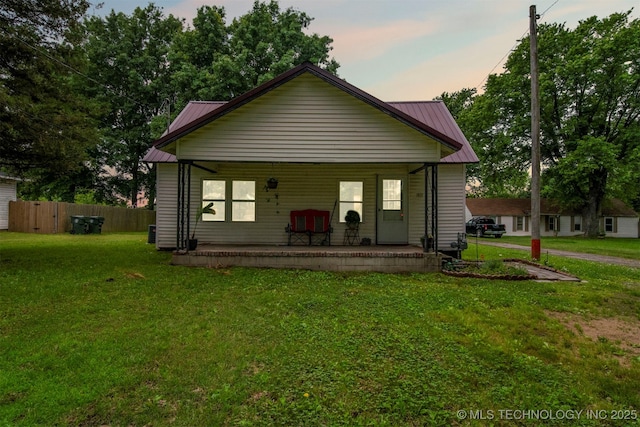 view of front facade with covered porch and a lawn