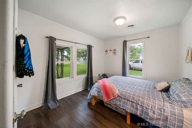 bedroom with dark hardwood / wood-style floors and crown molding