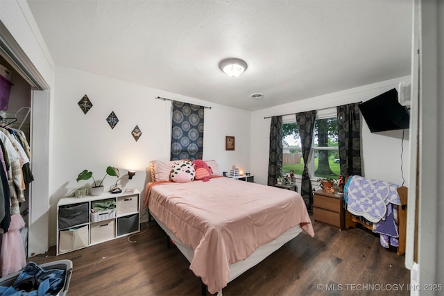 bedroom featuring a textured ceiling and dark hardwood / wood-style floors